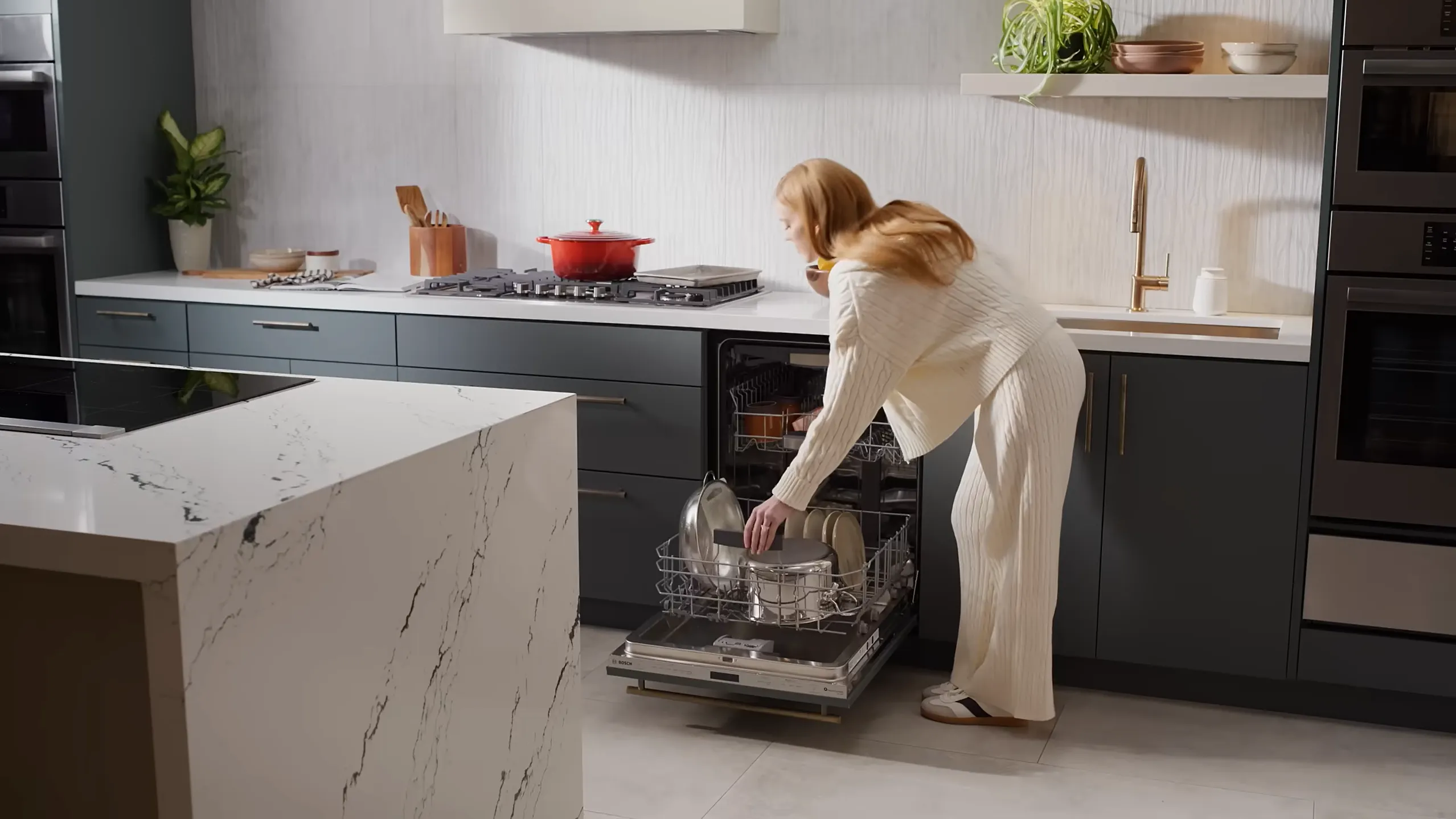 woman putting dishes into Bosch dishwasher