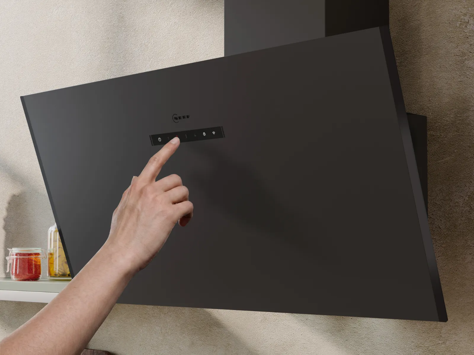 Hand touching the control panel of a sleek black Neff kitchen ventilation hood mounted on a textured wall.