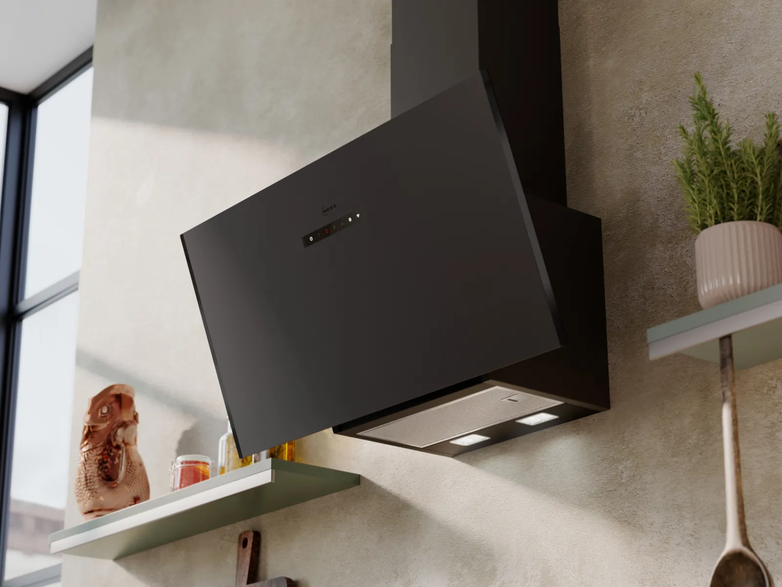 Black angled kitchen range hood mounted on a beige wall with shelves, herbs, cutting boards, and kitchen utensils nearby.