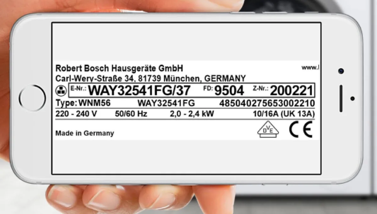 Käsi hoiab älypuhelint, mille ekraanil on Bosch kodinöökonei silt toote detailidega pesumasina taustal.