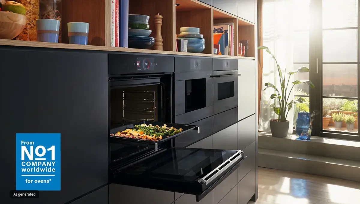 Bosch kitchen with builtin oven with tray of roasted vegetables, wooden shelves with dishes, and sunlight from large window.