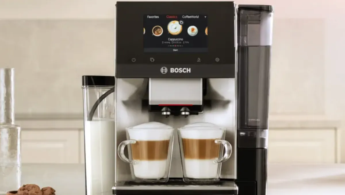 Bosch fully automatic coffee machine with dual spouts preparing two layered lattes in glass cups on a kitchen countertop.