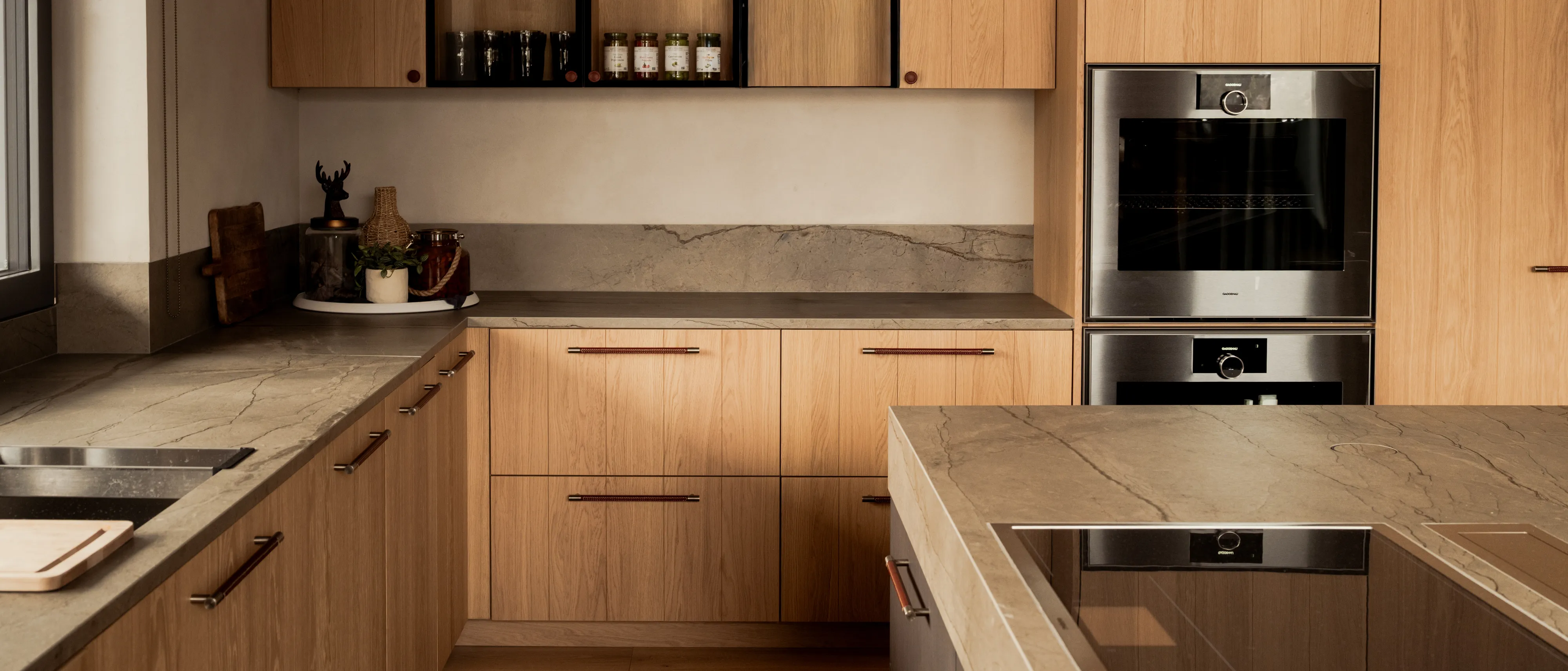 Brightly lit luxury kitchen featuring Gaggenau appliances including Expressive series ovens