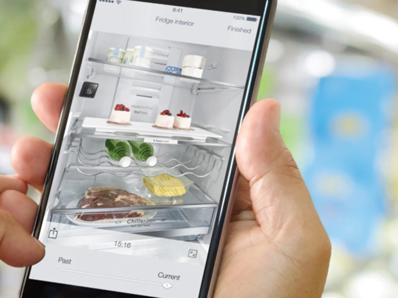 Eine Person im Supermarkt, die über ein Smartphone mit der Home Connect App den aktuellen Inhalt ihres smarten Kühlschranks überprüft.
