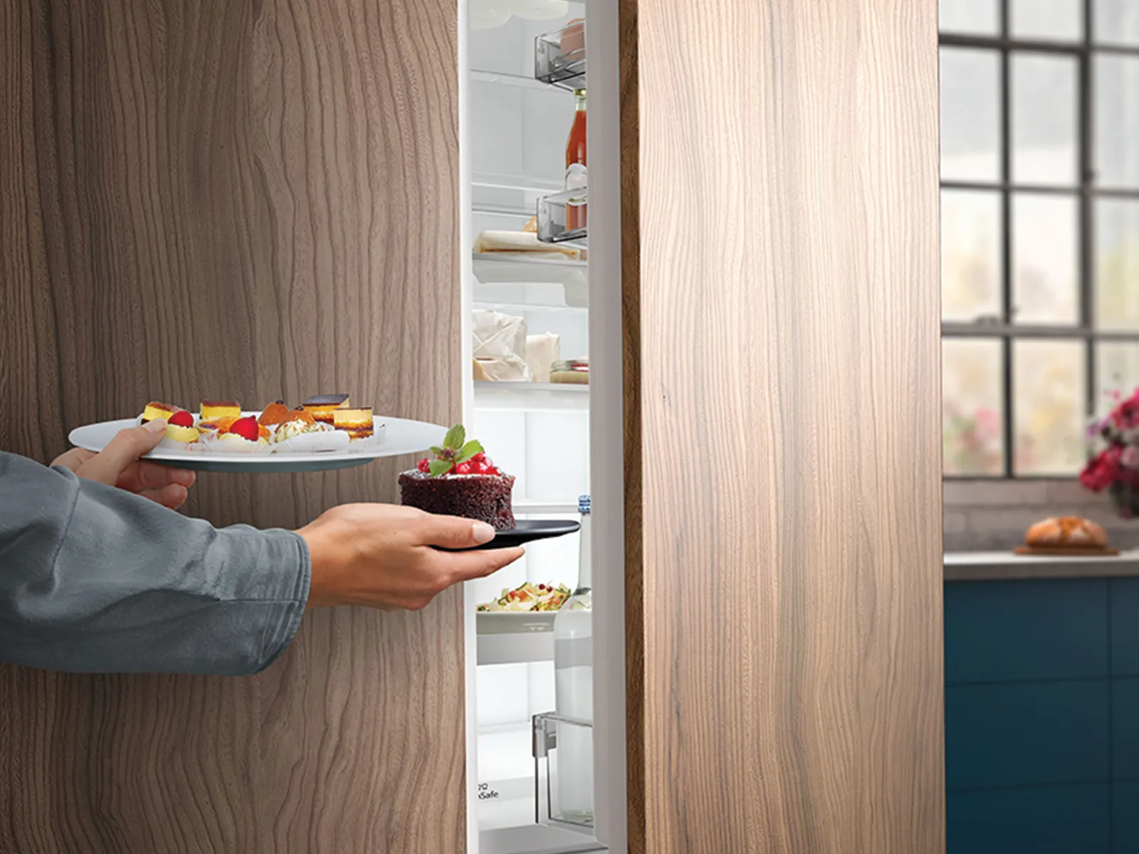 Eine Person öffnet einen Kühlschrank, auf dessen Ablagen ein Teller mit gesunden, frischen Köstlichkeiten steht.