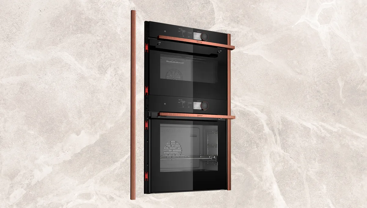 Double oven with black glass doors and red trim, modern kitchen appliance design.