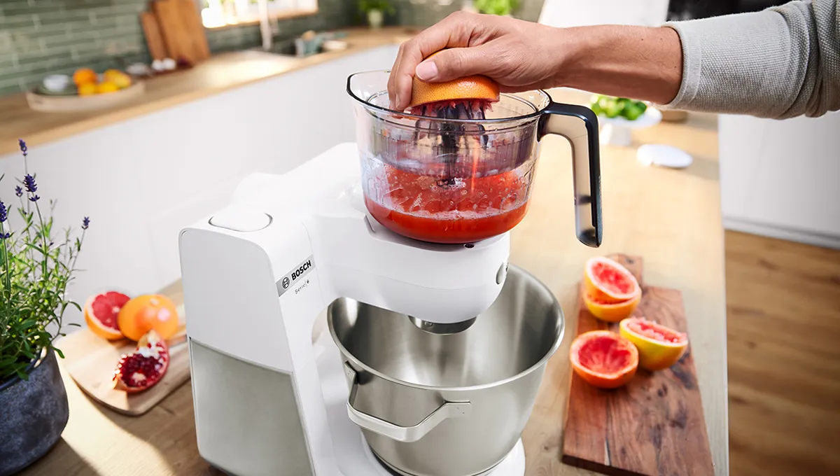 Series 6 sitrus sıxacağı aksesuarından istifadə edərək şirə sıxan şəxs.