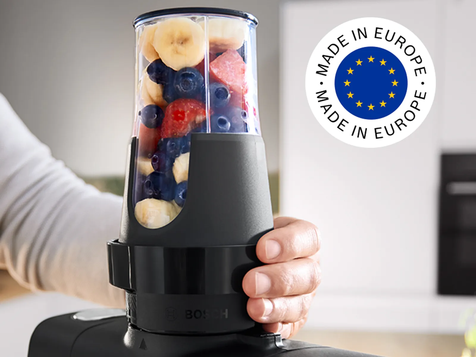 Series 6 stand mikserdən istifadə edərək meyvə smuzisi hazırlayan şəxs, əlində ToGo butulkası və kadrda "Made in Europe" loqosu görünür.