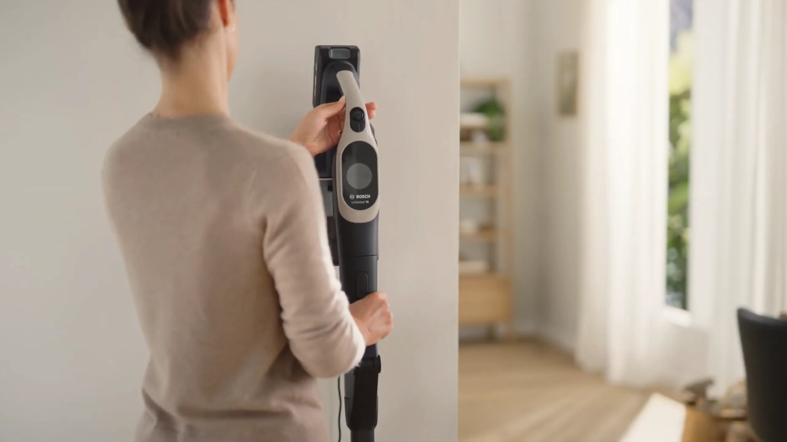 Woman docking her Bosch Vacuum on the wall
