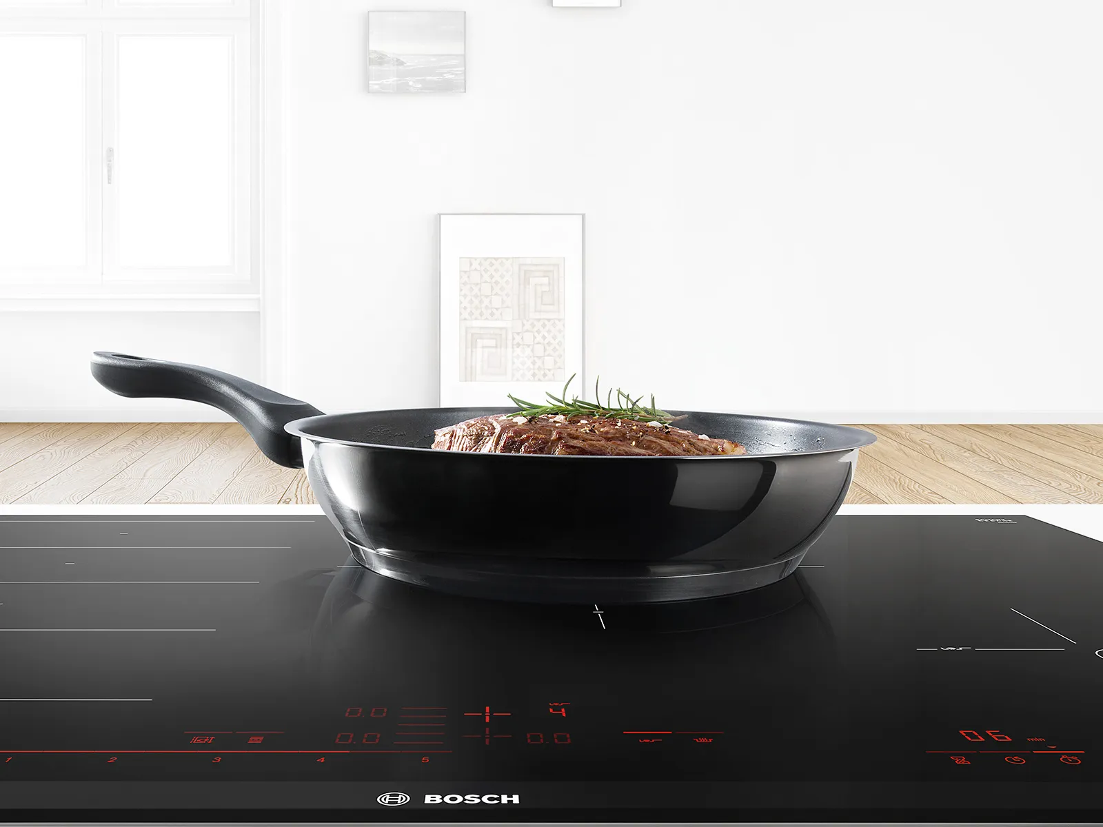 Sartén negra con alimentos sobre una placa de inducción en una cocina moderna.