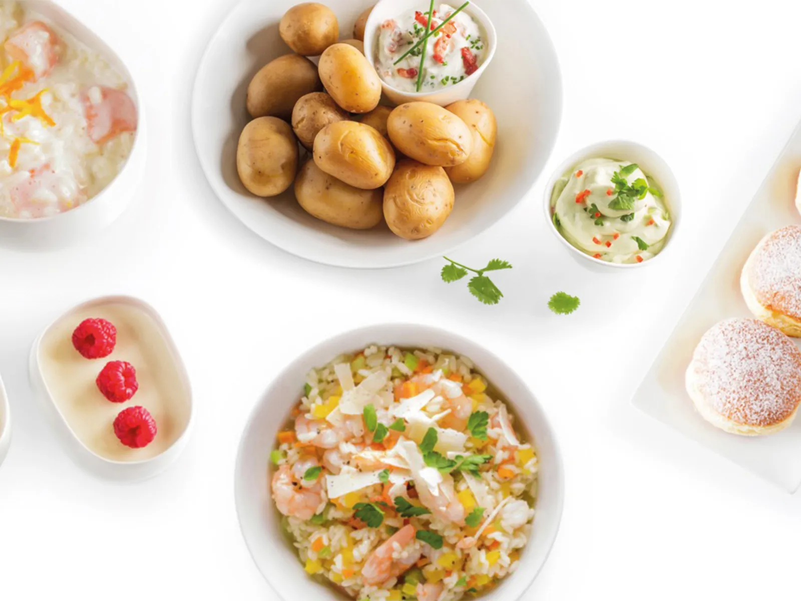 Variedad de platos que incluye sopa, papas, arroz y repostería sobre un fondo blanco.