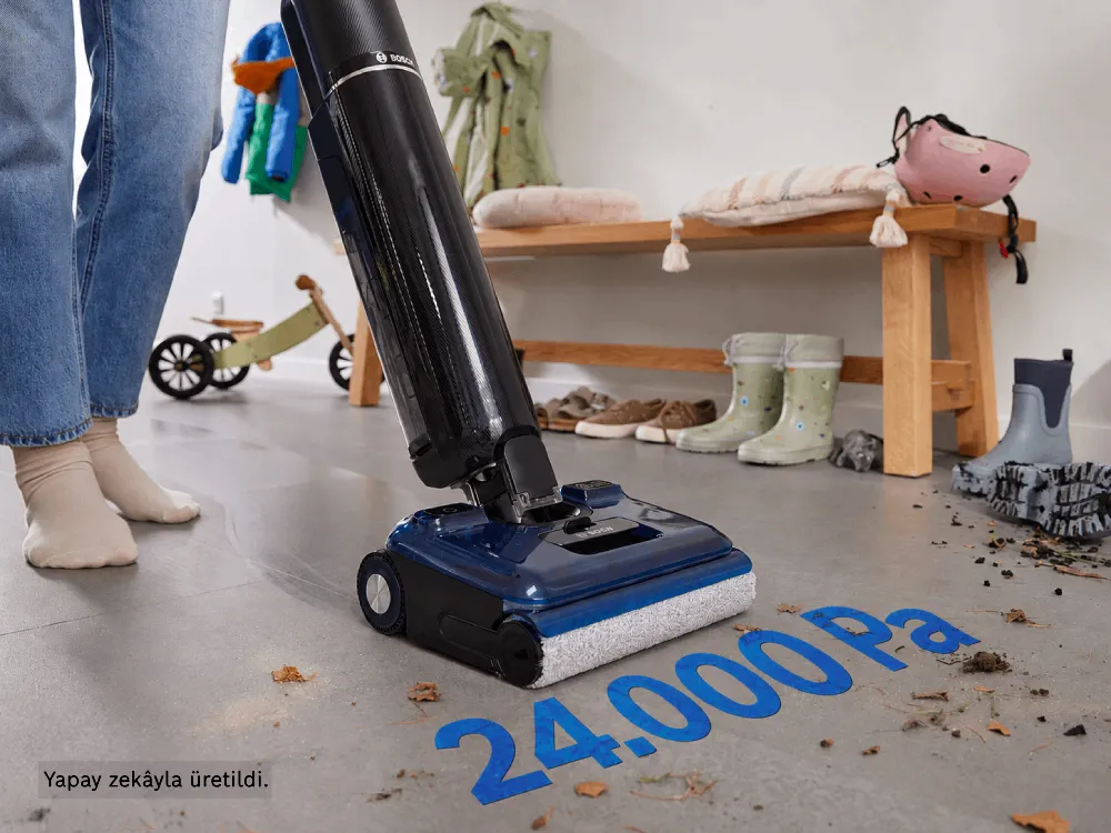A person uses the Bosch Floor Washer on a floor with large spills, in the background various kids toys can be seen.