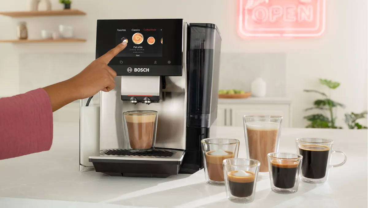 Person selecting a coffee option on a Bosch espresso machine, surrounded by various coffee drinks in clear glass cups.