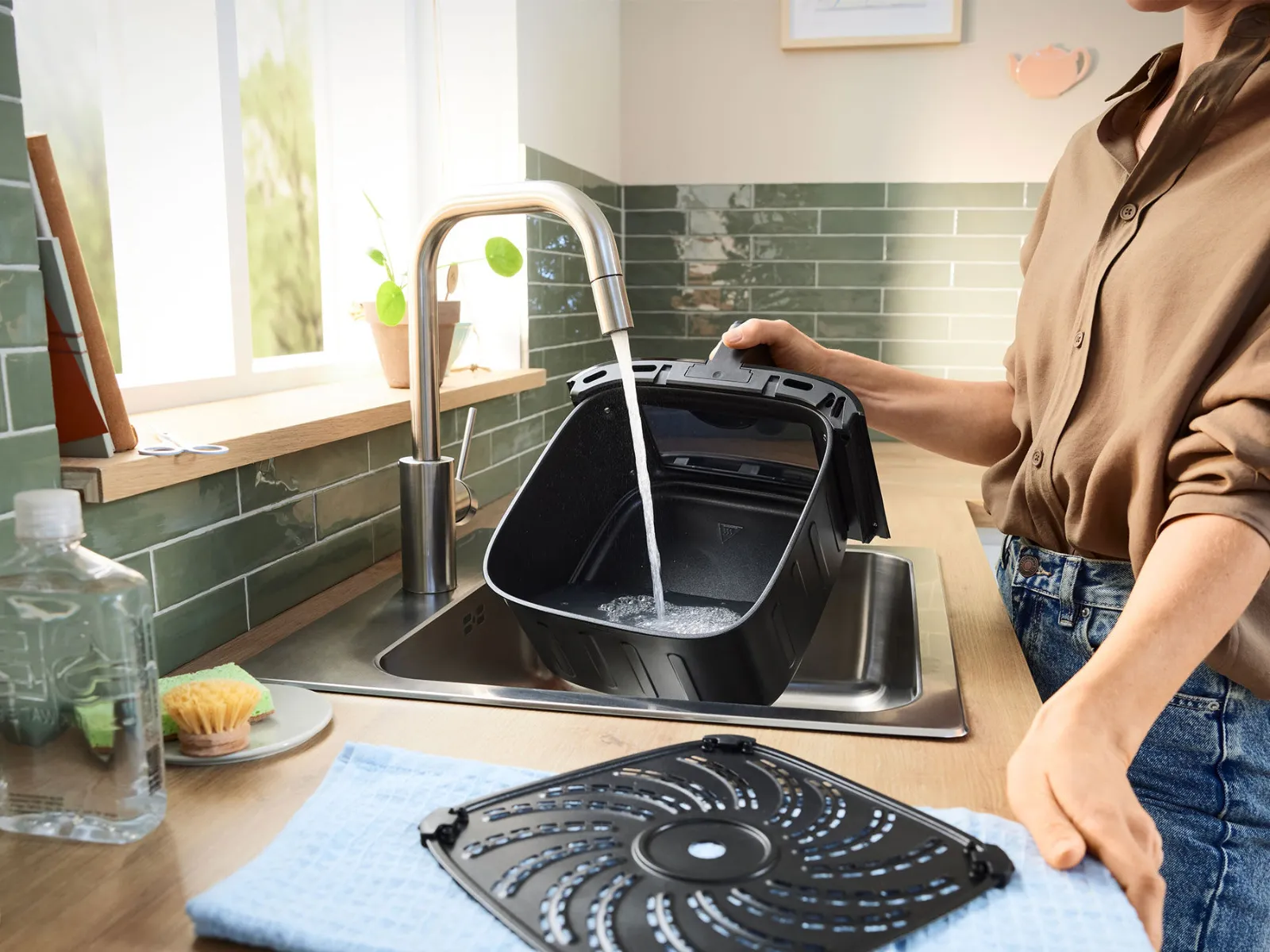 Il cestello della friggitrice ad aria calda si pulisce facilmente sotto l'acqua corrente.