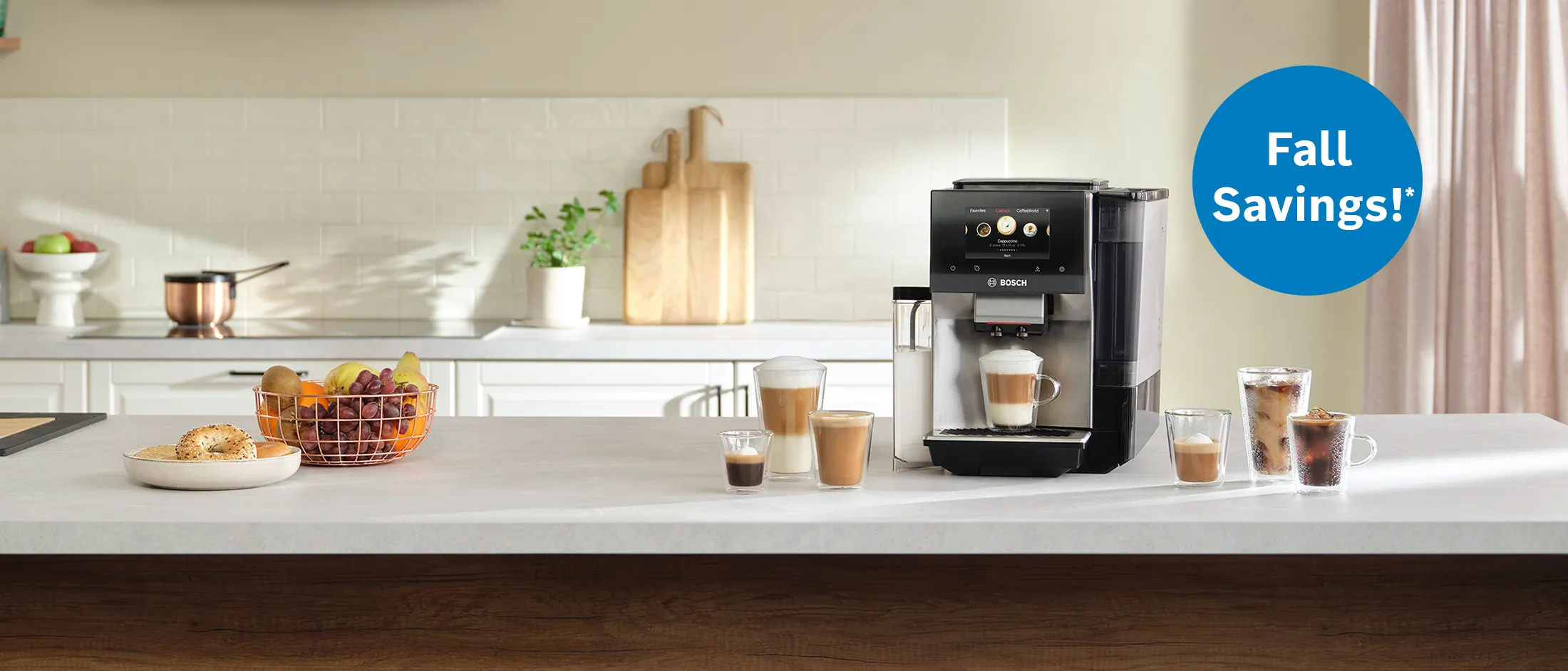 Bosch Espresso Machine on top of white countertop with cups of coffee and fruit next to it