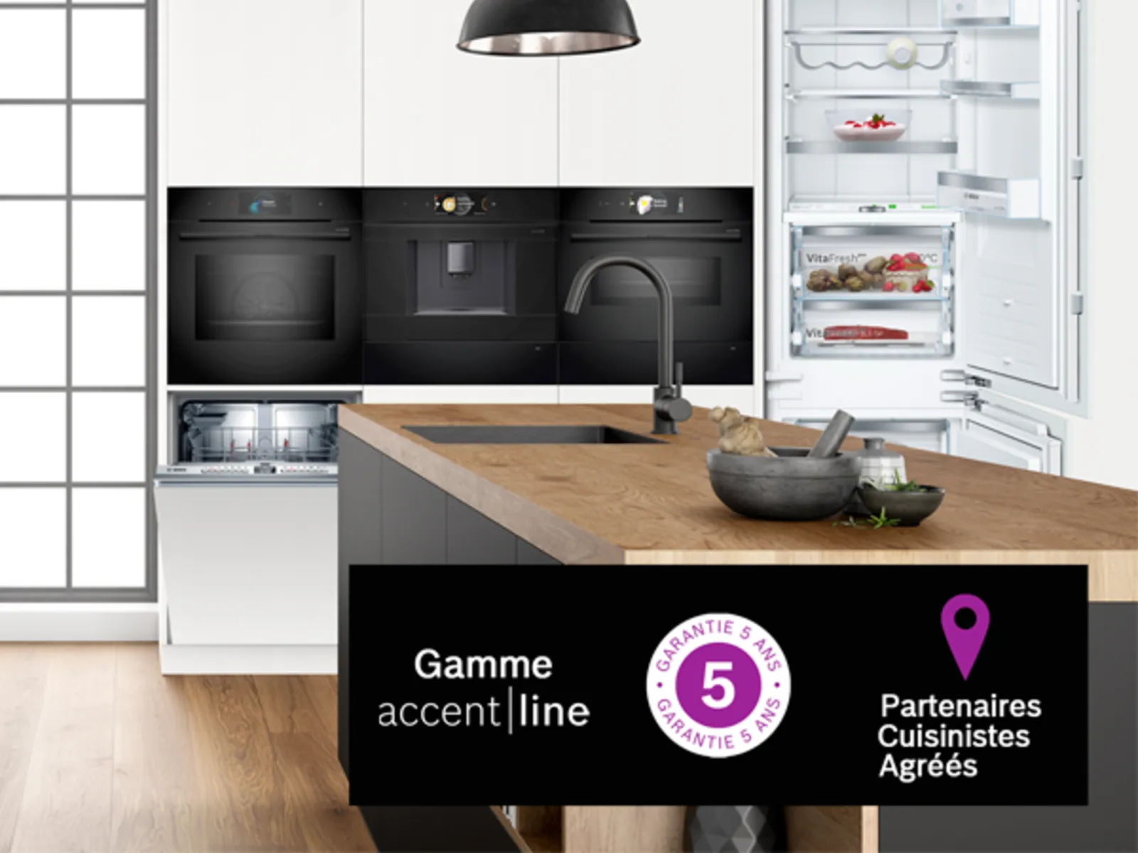 Cuisine moderne avec électroménagers noirs, comptoir en bois et lampes pendentif.
