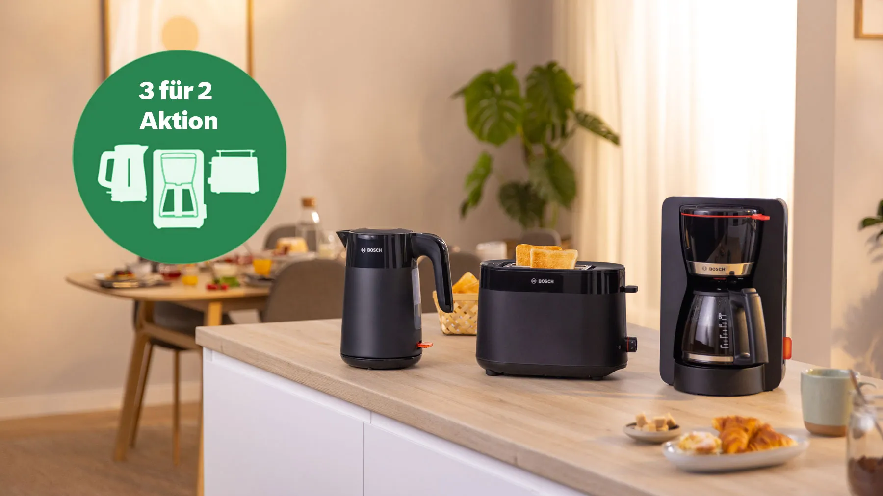 Heller Raum mit einem Bosch Frühstücksset, bestehend aus Wasserkocher, Toaster und Kaffeemaschine auf einer Küchenzeile.