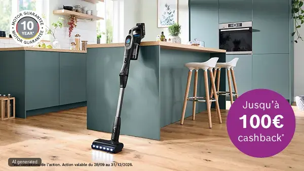 Aspirateur-balai posé sur un sol en bois devant un îlot de cuisine aux meubles vert-bleu et des tabourets ; des LED sur la brosse éclairent le sol. En haut à gauche, un badge rond libellé «10 year motor guarantee», en bas à droite un cercle violet indiquant «Jusqu'à 100€ cashback*».