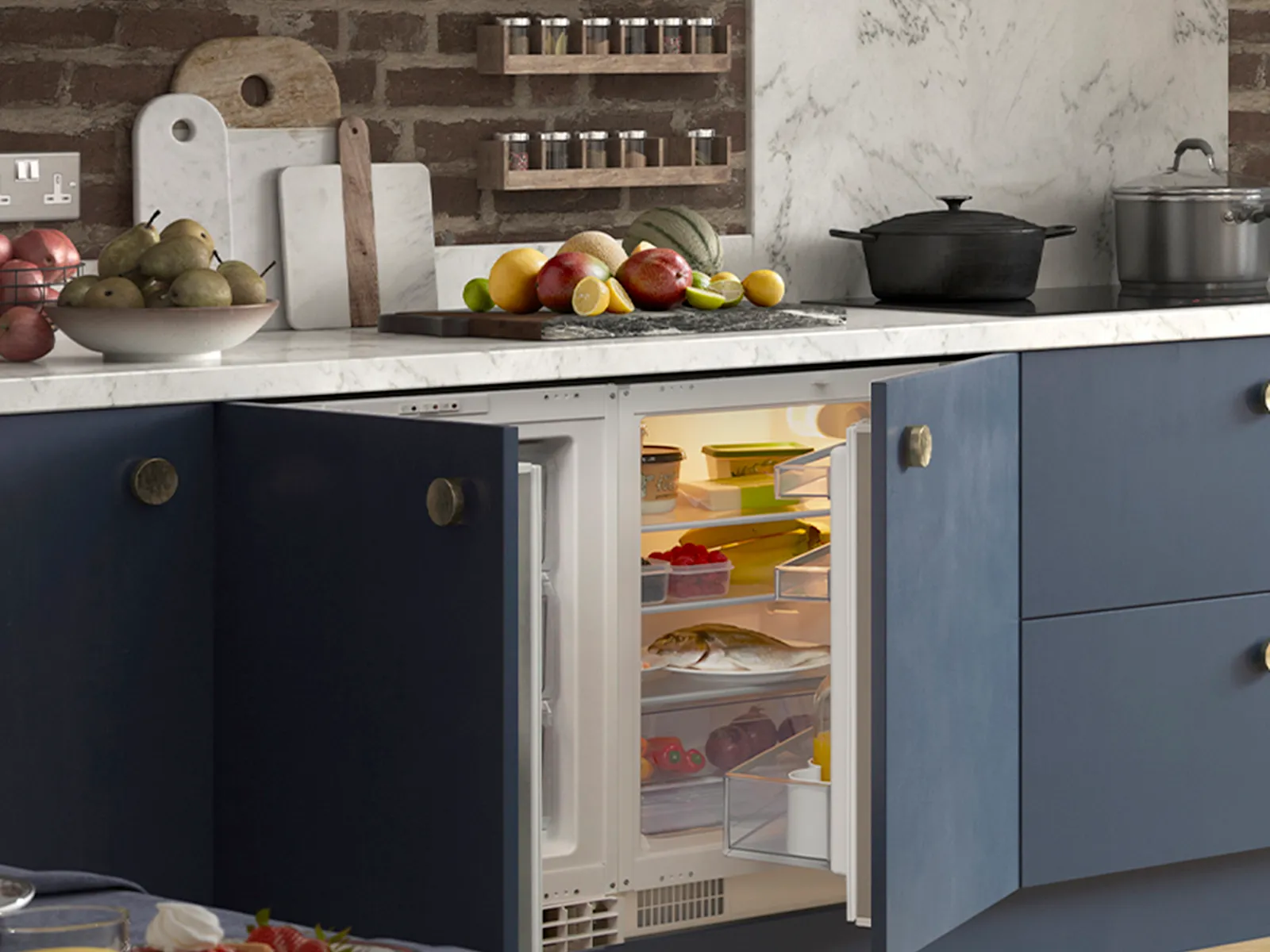 A well-stocked, under-counter NEFF integrated refrigerator with its blue cabinet door open, sitting below a white marble countertop laden with fresh fruits.