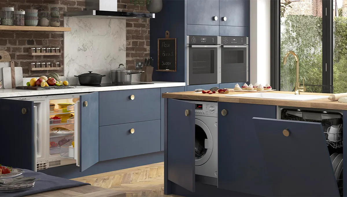 A full view of a kitchen with blue cabinets, showing various integrated NEFF appliances, including an under-counter fridge, washing machine, and dishwasher, all with their doors open.