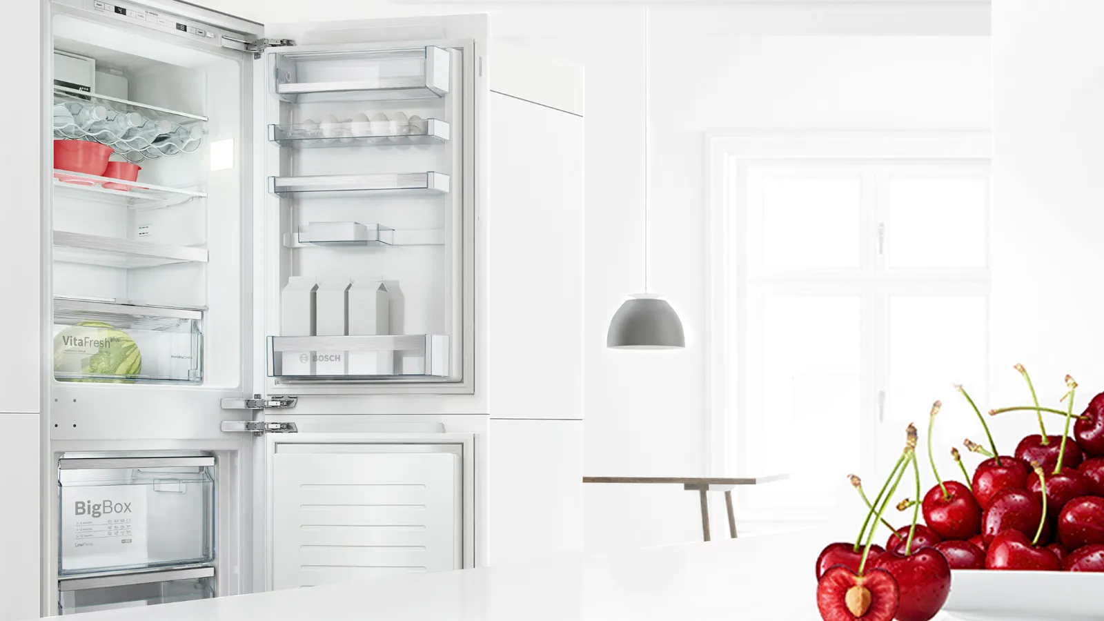 Open refrigerator with fresh cherries on plate in foreground.