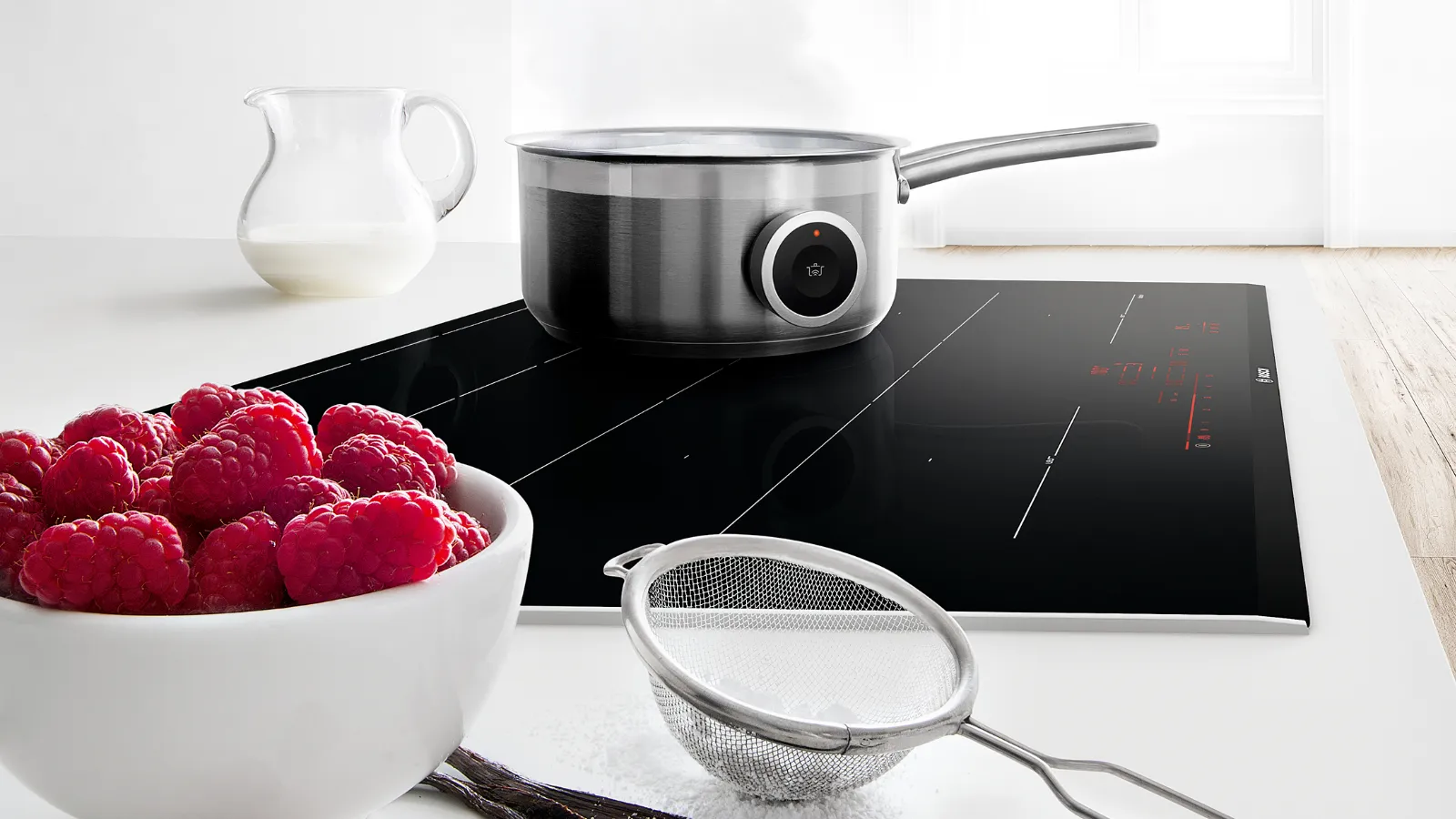 Induction cooktop, cookware, raspberries, kitchen utensils, wooden table, minimalist interior.