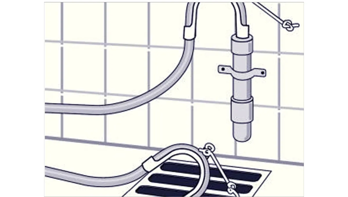 Bathroom sink faucet and drain with tiled wall background.