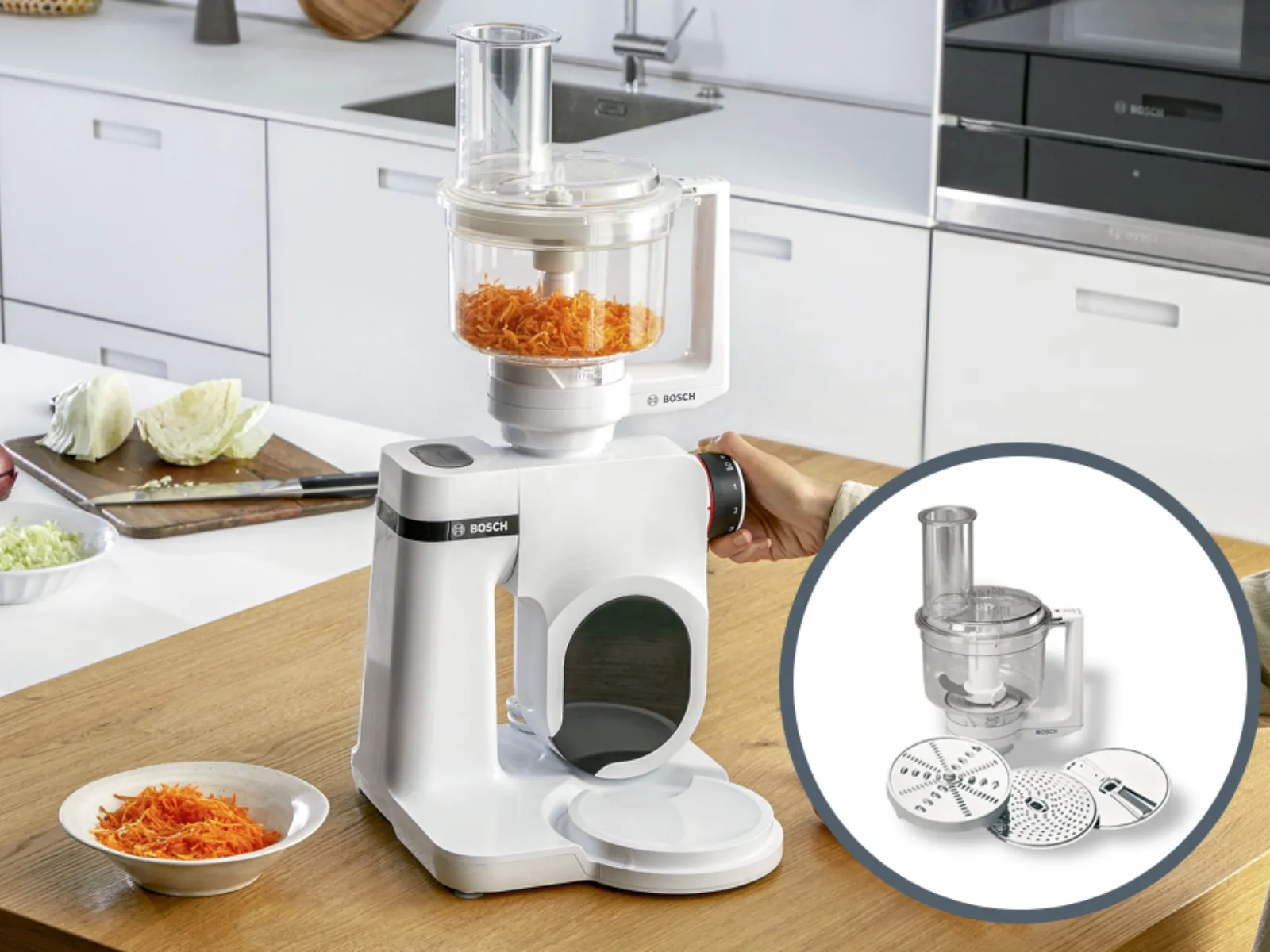 Kitchen counter with food processor, vegetables, and kitchen utensils.