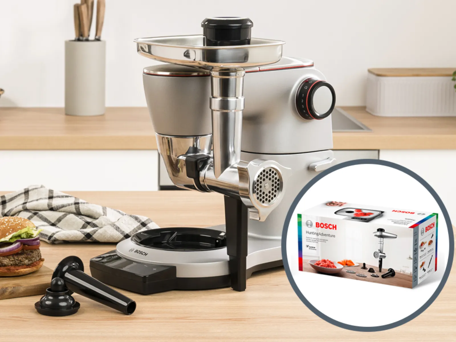 Kitchen appliances, food preparation tools, and homemade burgers on a wooden countertop.