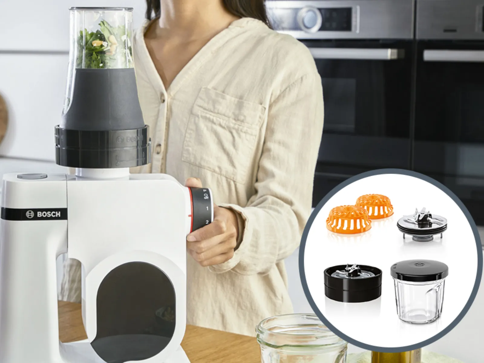 Woman using Bosch blender with various attachments on kitchen counter.