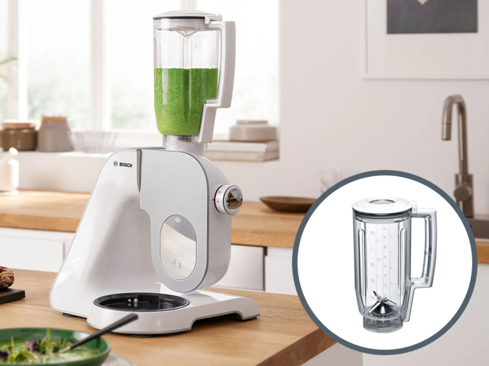 Kitchen countertop with blender, food items, and a glass blender jar filled with green smoothie.