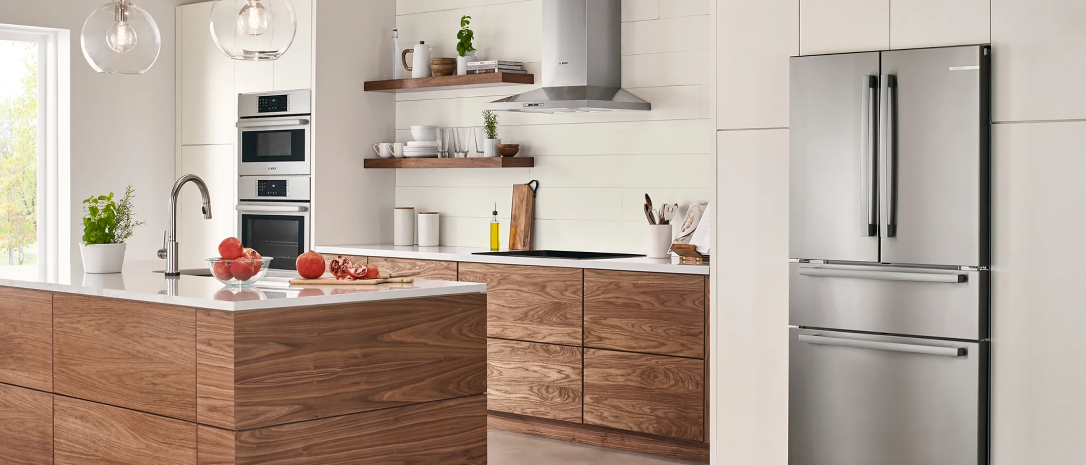Modern kitchen with a Bosch stainless steel refrigerator on the right and dark wooden cabinets