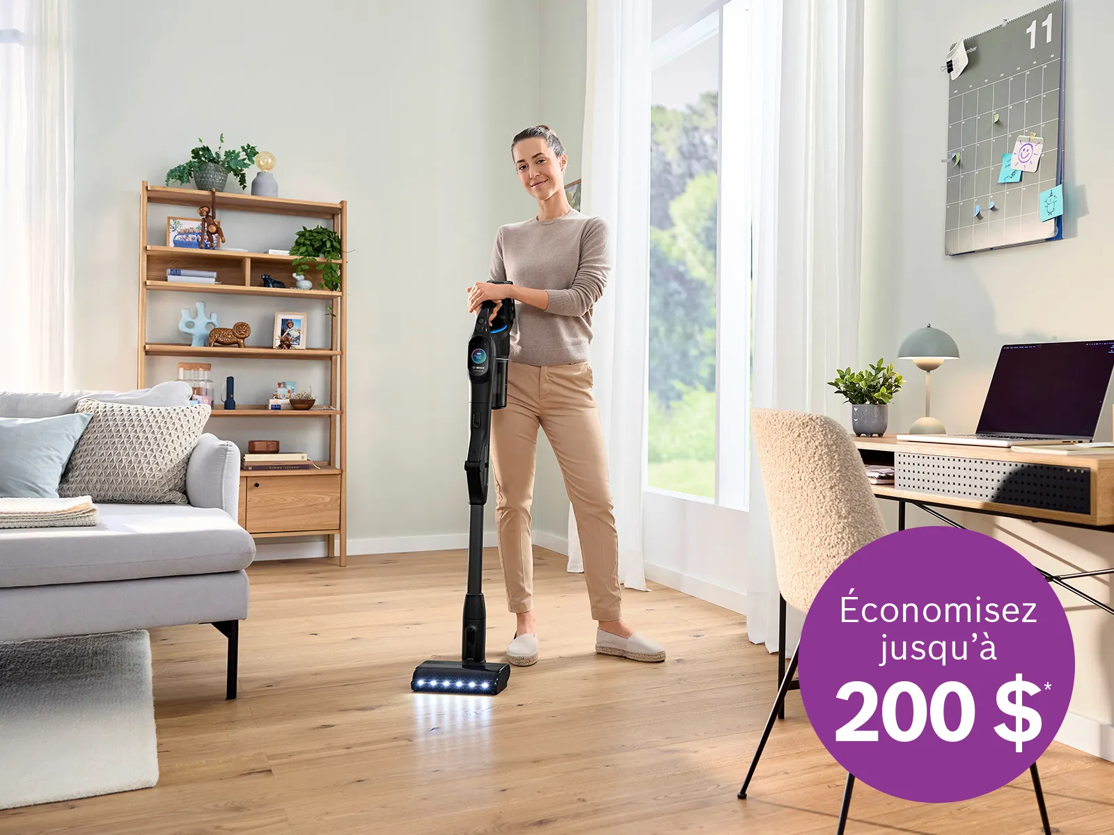 Personne passant l'aspirateur dans un salon lumineux avec un aspirateur sans fil; un macaron violet annonce des économies allant jusqu'à 200$