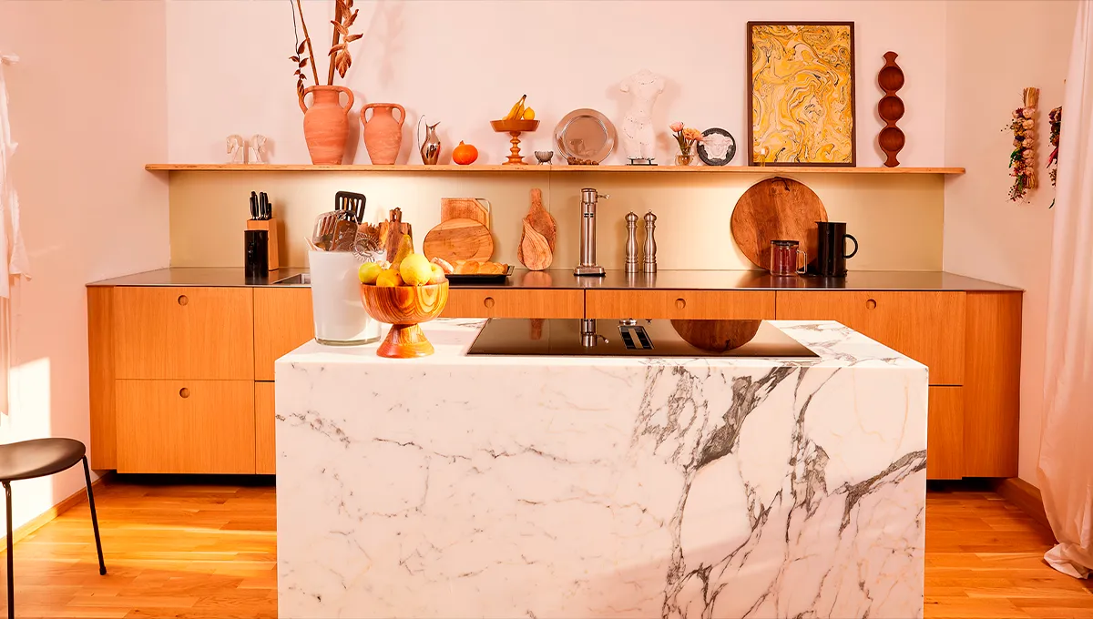 Cozy kitchen with marble countertop, wooden cabinets, and decorative items on shelves.