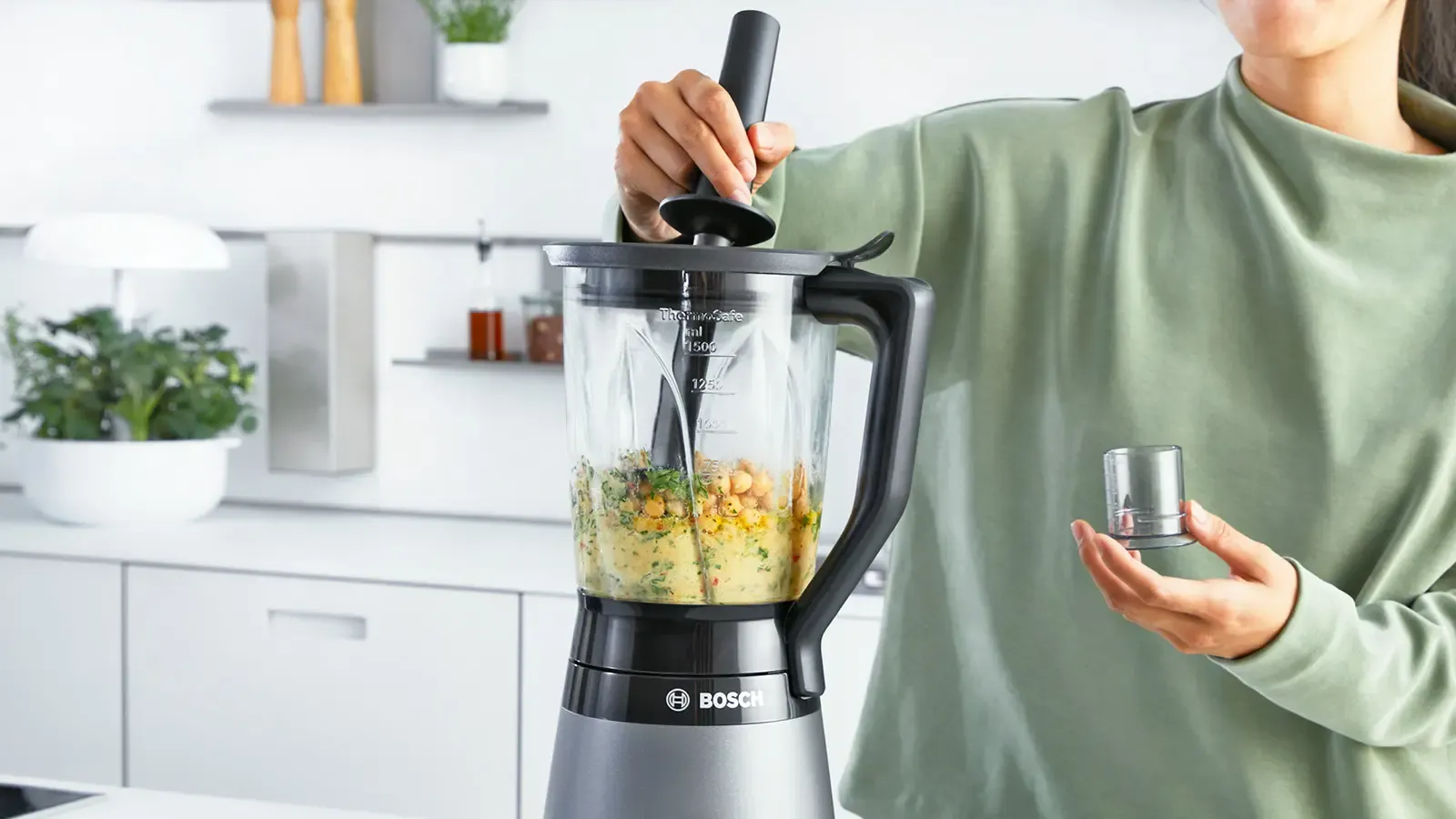 Person using pusher to blend chickpeas on VitaPower Series 4.