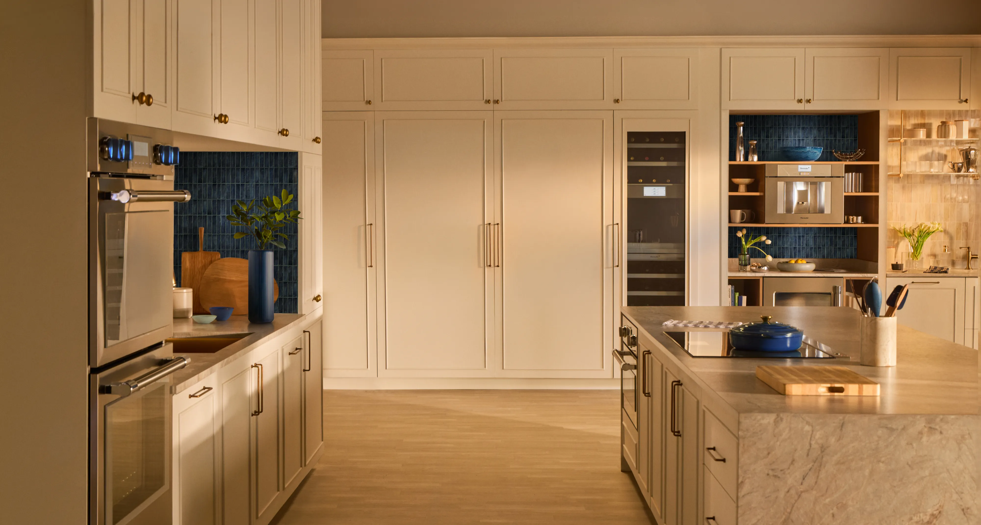 Modern kitchen with a custom Thermador panel refrigerator, stainless steel appliances, and a white marble island