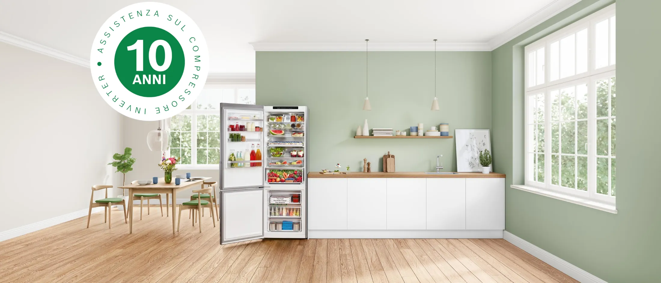 Luminosa cucina moderna con pareti verdi, pavimento in legno, tavolo da pranzo e elettrodomestici.
