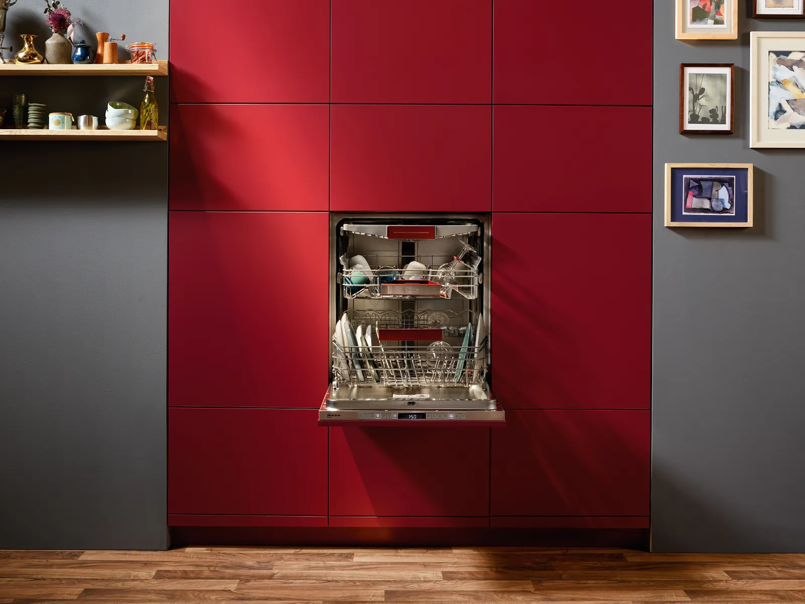An open, built-in dishwasher integrated into red cabinetry