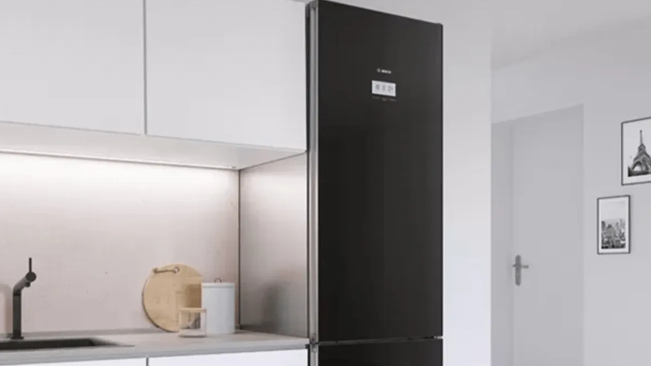 Siyah buzdolabı, beyaz kabinler ve minimum dekorasyon ile modern mutfak.