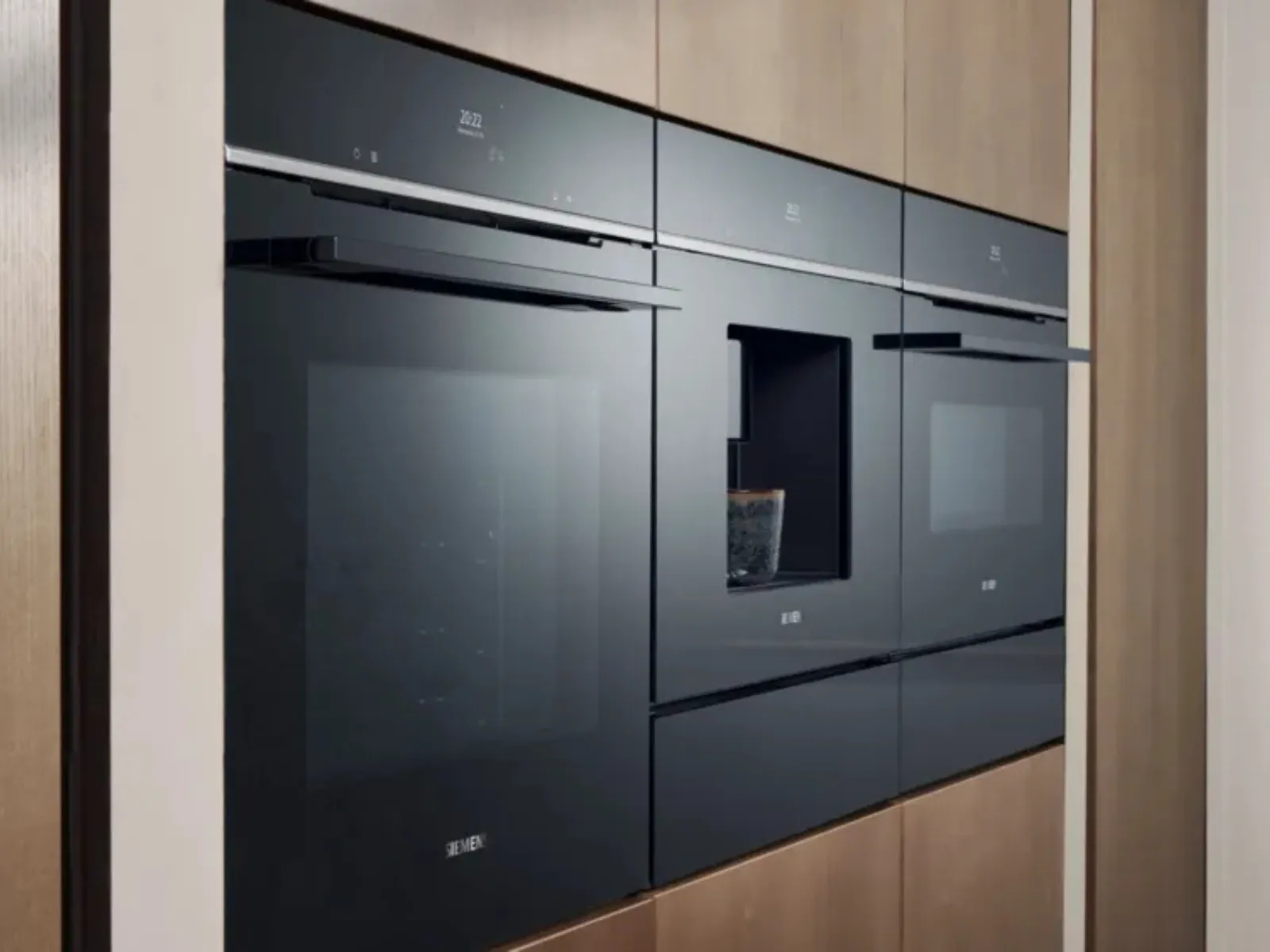 Electrodomésticos de cocina modernos y muebles de madera oscura y diseño minimalista en un interior elegante y sofisticado.
