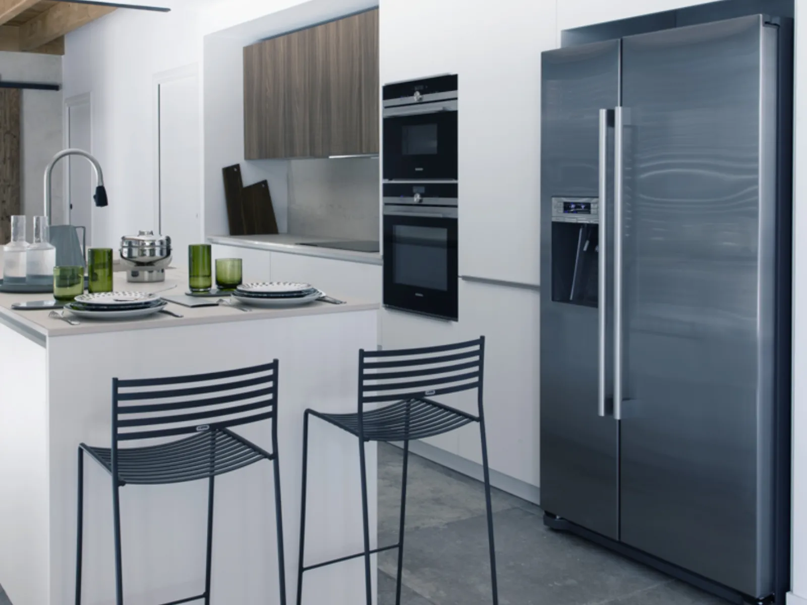 Cucina moderna con armadi bianchi, elettrodomestici in acciaio inossidabile e travi in legno.