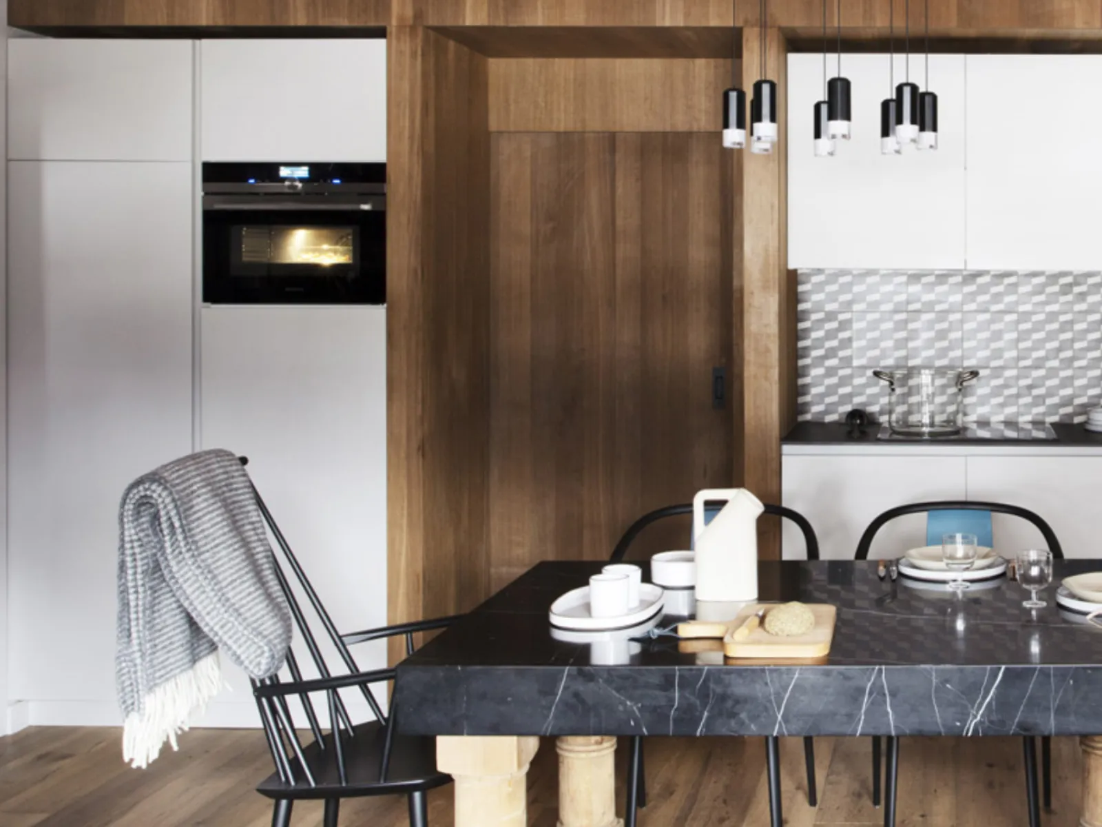 Cucina rustica con pareti in legno, elettrodomestici moderni, e un grande tavolo da pranzo con sedie.