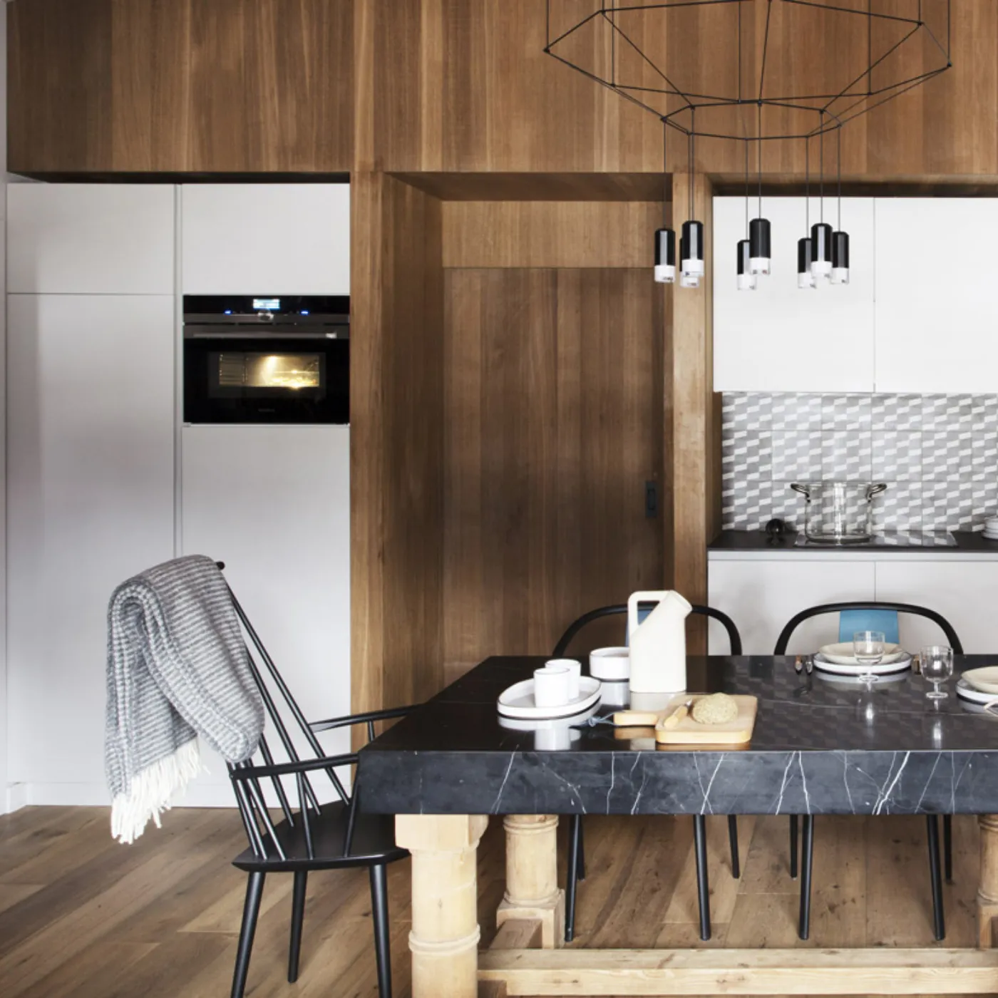 Cucina rustica con pareti in legno, elettrodomestici moderni, e un grande tavolo da pranzo con sedie.