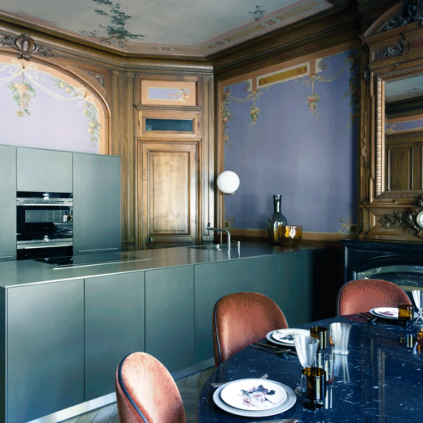 Cucina decorata con mobili verdi, arredamento antico, e una stufa vintage in un interno storico.