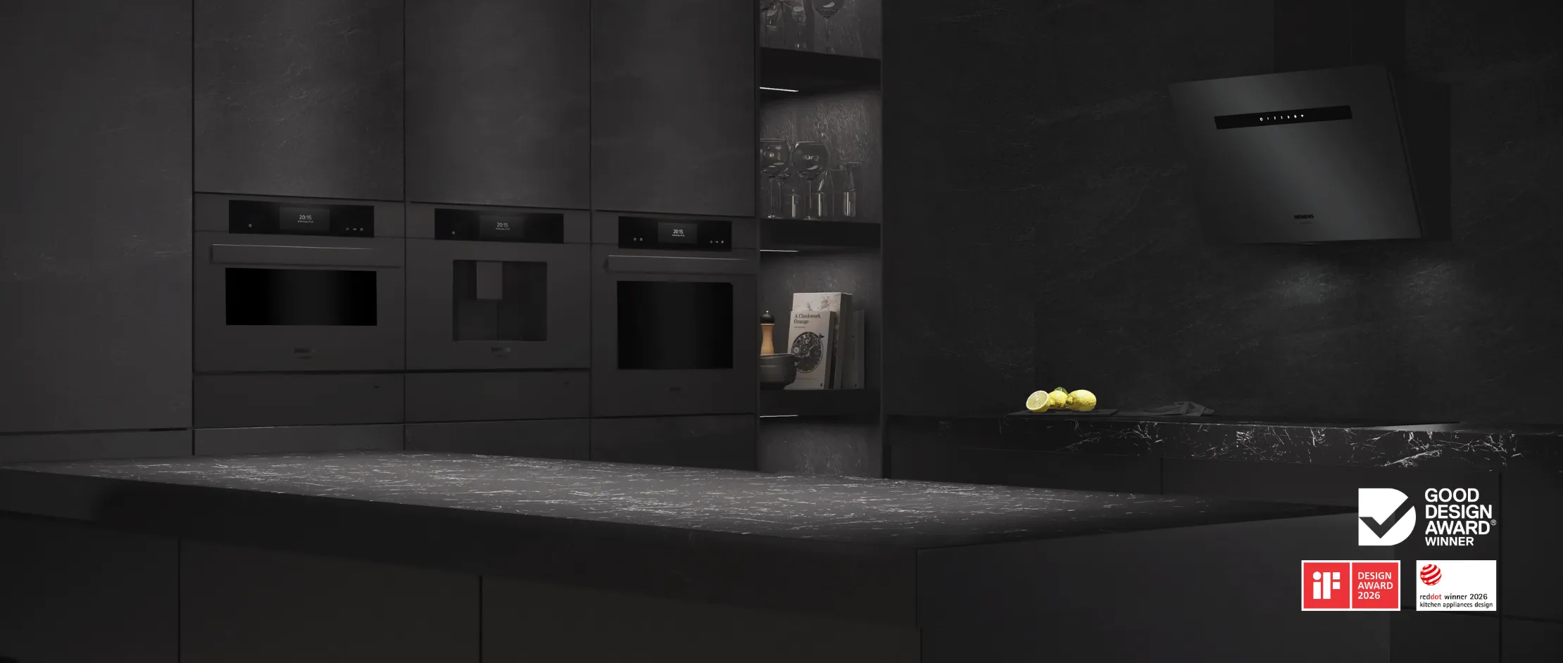 Modern black kitchen island with sleek appliances, a faucet, and potted herbs, showcasing the German Design Award Winner 2026 logo.