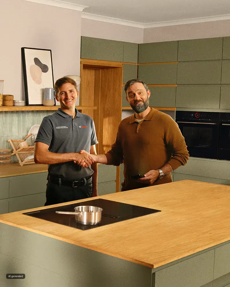Two men standing in a modern olive-green kitchen with wooden countertops, built-in appliances, and Bosch kitchen equipment. A badge reads “Award Winning Customer Service.”
