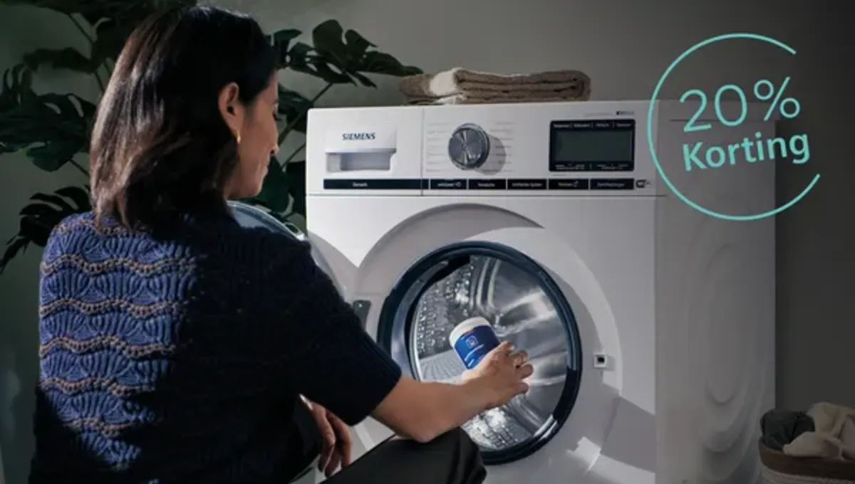Dame voor wasmachine met reinigingsmiddel in haar hand. 