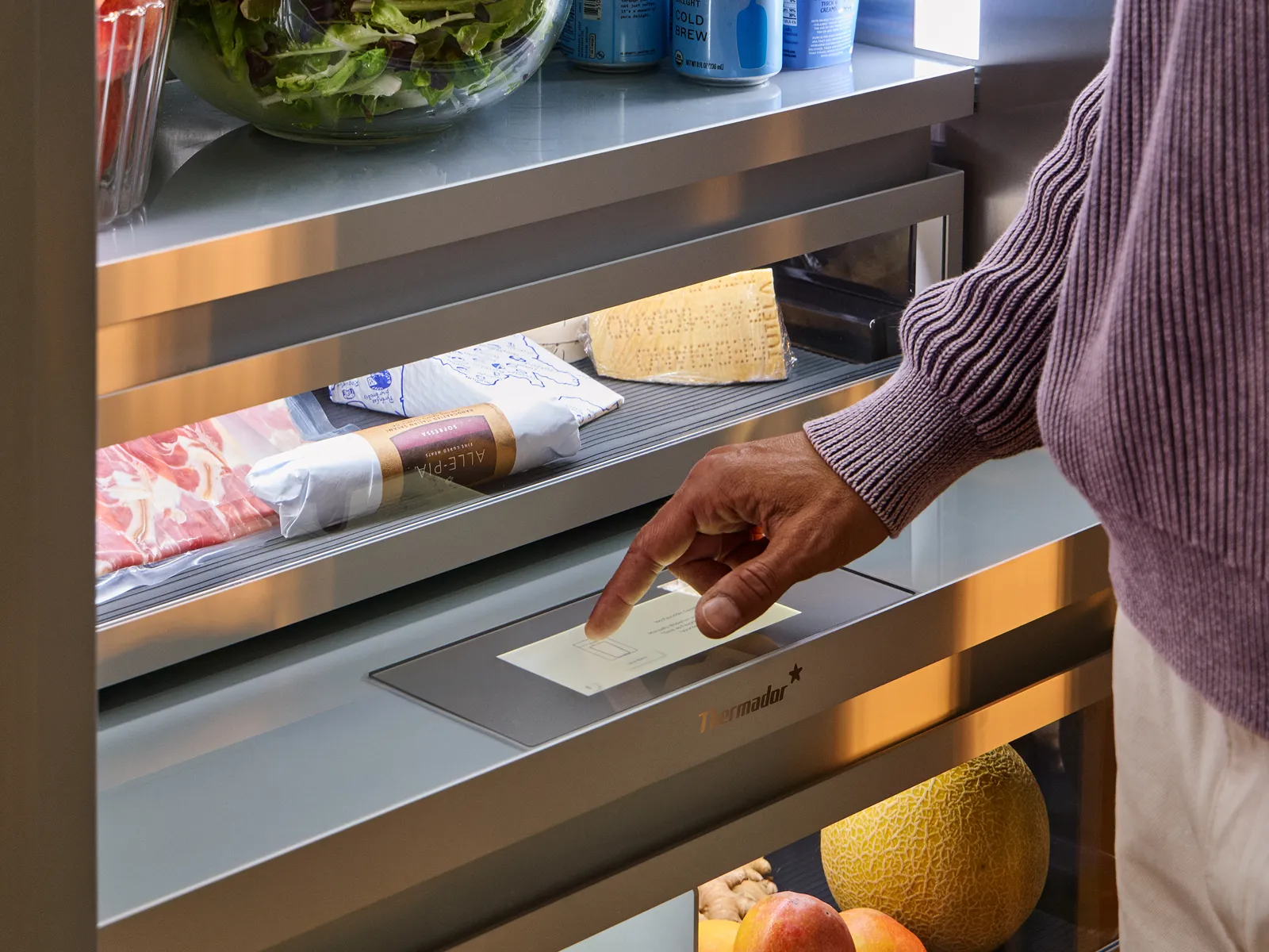 close up of thermador refrigeration column with hand touching touchscreen display