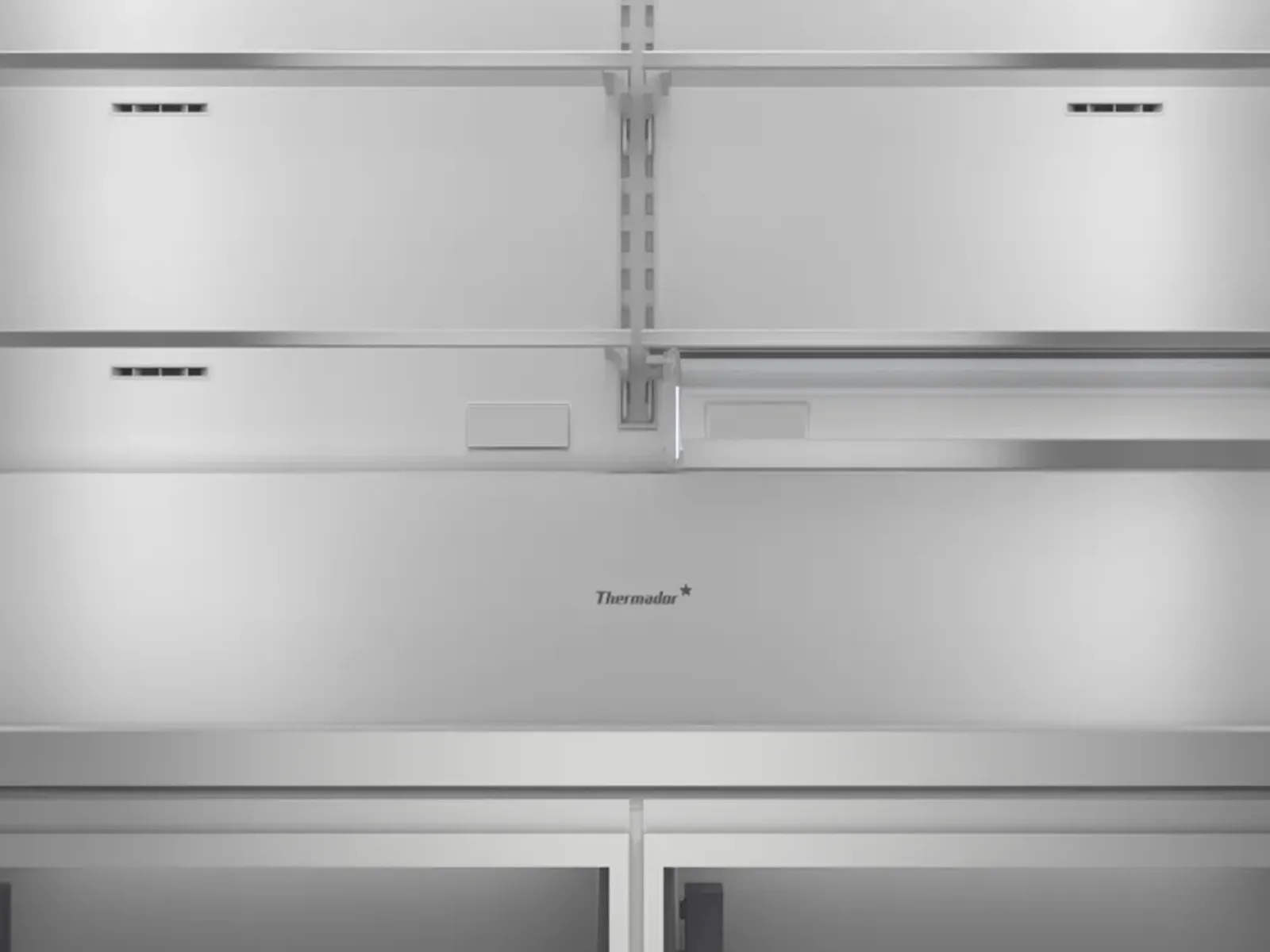 Thermador refrigerator interior with shelves, grey finish, and storage compartments visible.