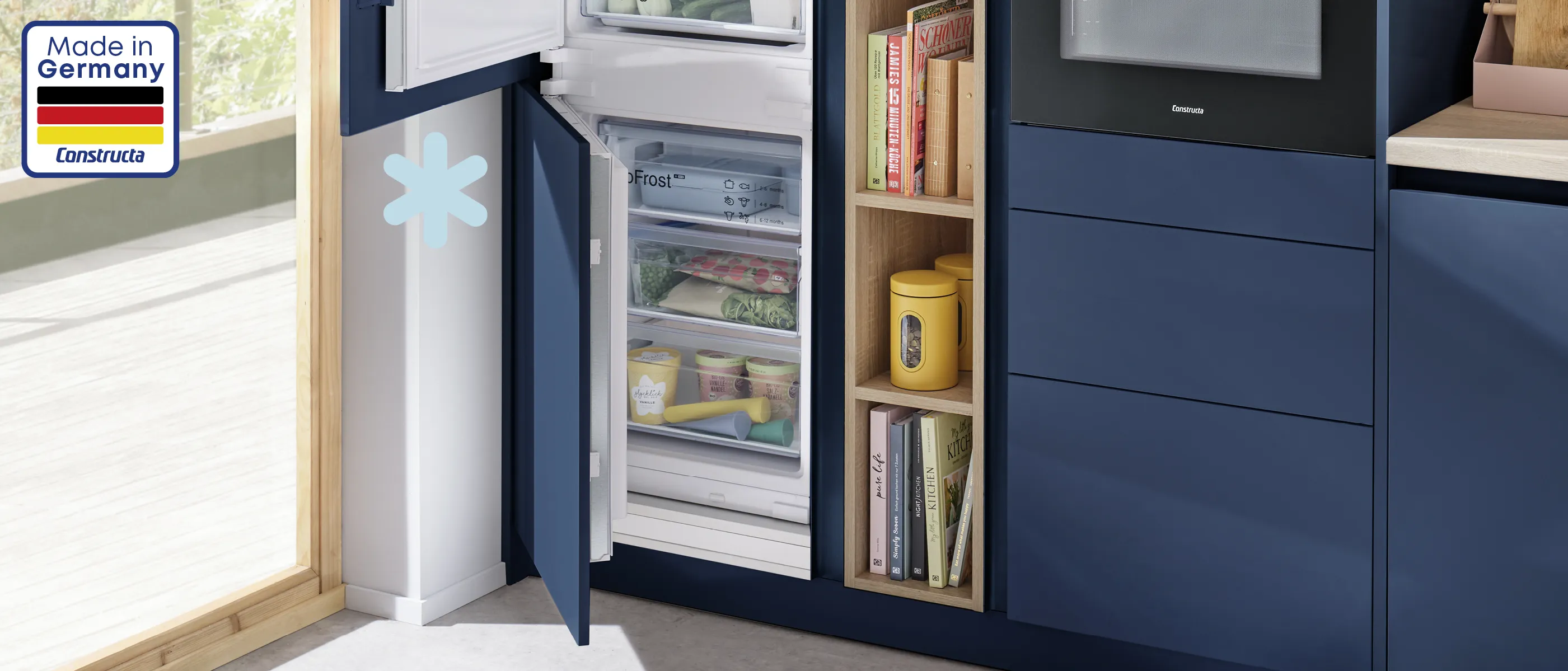 Küchenschrank mit offenem Kühlschrank, Bücher und andere Haushaltsartikel.
